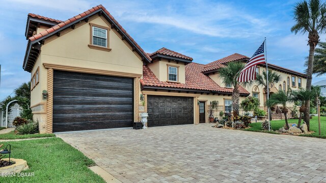 mediterranean / spanish-style house with a garage and a front yard