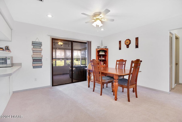 dining room featuring ceiling fan and light carpet