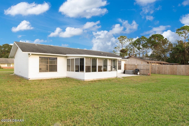 back of property featuring a sunroom and a lawn