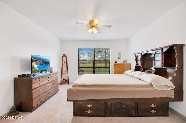 bedroom featuring ceiling fan, multiple windows, a textured ceiling, and light colored carpet