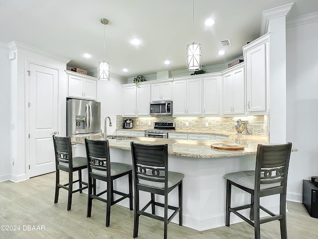 kitchen featuring pendant lighting, stainless steel appliances, and a breakfast bar area