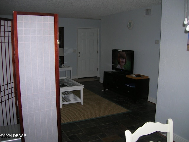 living room featuring a textured ceiling and dark tile patterned floors