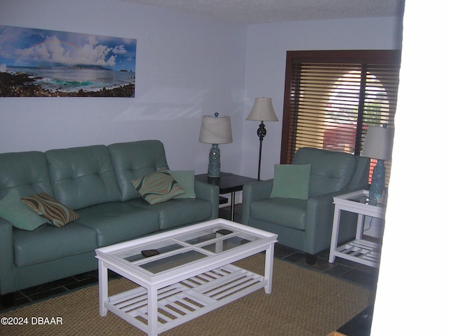 tiled living room featuring a textured ceiling