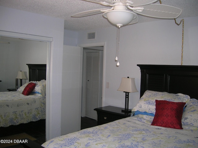 bedroom with ceiling fan and a textured ceiling