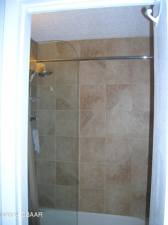 bathroom with tiled shower / bath and a textured ceiling