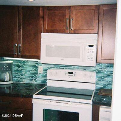 kitchen featuring white appliances and backsplash