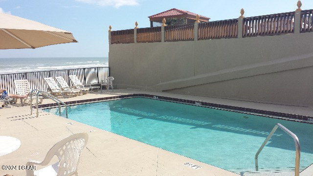 view of pool featuring a beach view and a water view