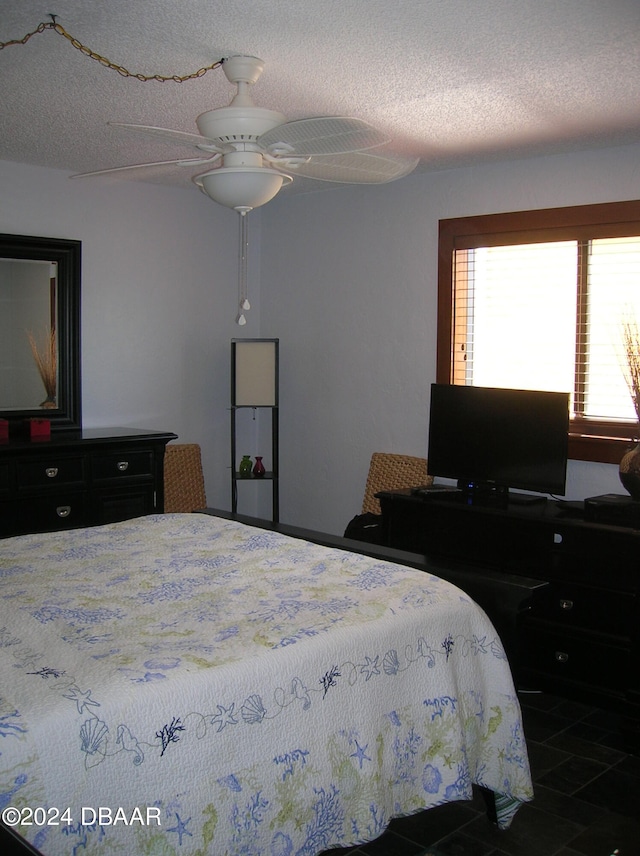 tiled bedroom featuring a textured ceiling and ceiling fan