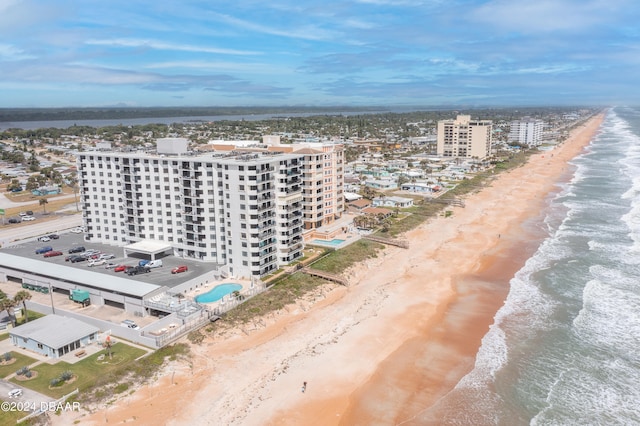 drone / aerial view featuring a beach view and a water view