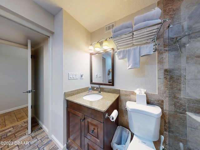 520 S Peninsula Ave Unit 2D7, New Smyrna Beach, FL 32169 - bathroom featuring hardwood / wood-style floors, vanity, toilet, and a tile shower