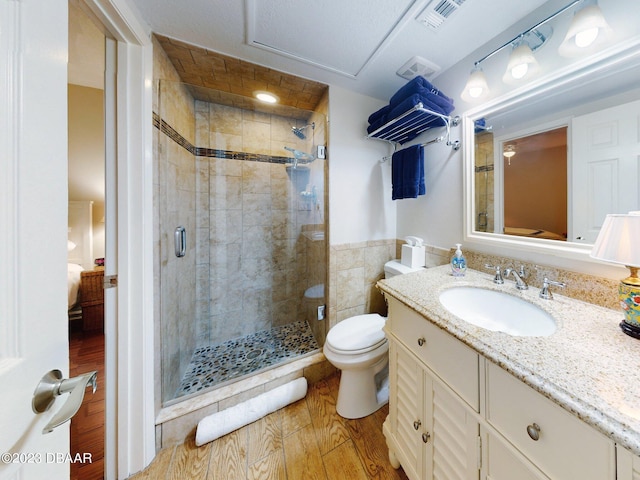 520 S Peninsula Ave Unit 2D7, New Smyrna Beach, FL 32169 - bathroom with walk in shower, vanity, hardwood / wood-style flooring, and toilet