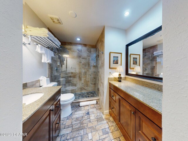 520 S Peninsula Ave Unit 2D7, New Smyrna Beach, FL 32169 - bathroom featuring toilet, an enclosed shower, and vanity