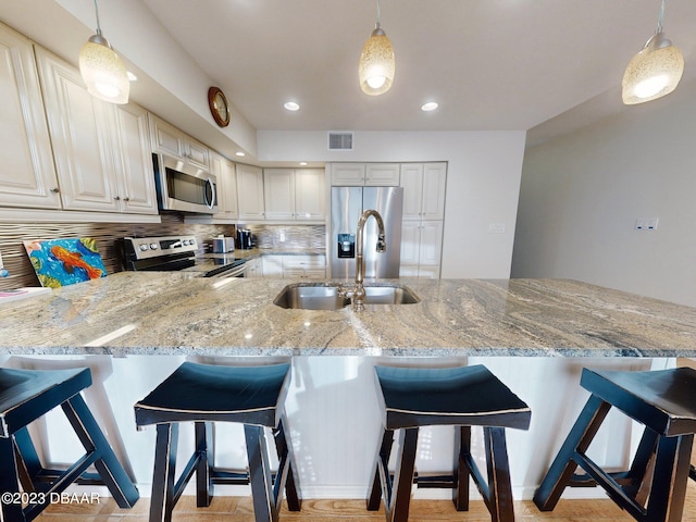 520 S Peninsula Ave Unit 2D7, New Smyrna Beach, FL 32169 - kitchen with pendant lighting, appliances with stainless steel finishes, sink, and a breakfast bar