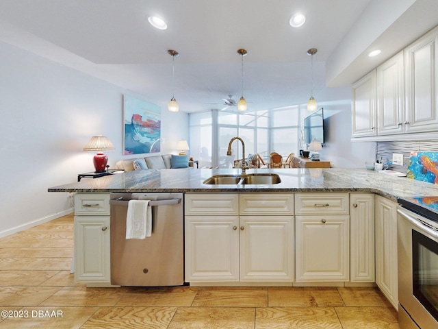 520 S Peninsula Ave Unit 2D7, New Smyrna Beach, FL 32169 - kitchen with kitchen peninsula, stainless steel appliances, sink, and decorative light fixtures
