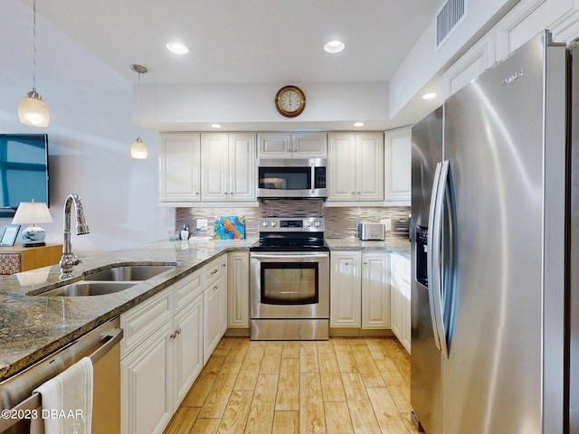 520 S Peninsula Ave Unit 2D7, New Smyrna Beach, FL 32169 - kitchen with white cabinetry, pendant lighting, sink, and stainless steel appliances