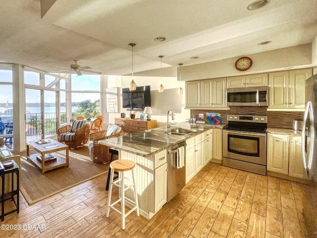 520 S Peninsula Ave Unit 2D7, New Smyrna Beach, FL 32169 - kitchen featuring sink, a breakfast bar, appliances with stainless steel finishes, and light hardwood / wood-style flooring