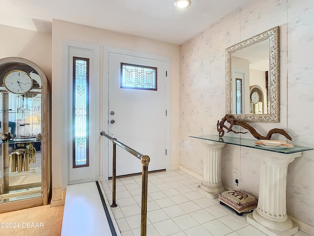 tiled entryway with plenty of natural light and a textured ceiling