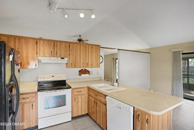 kitchen with light tile patterned floors, white appliances, sink, vaulted ceiling, and kitchen peninsula