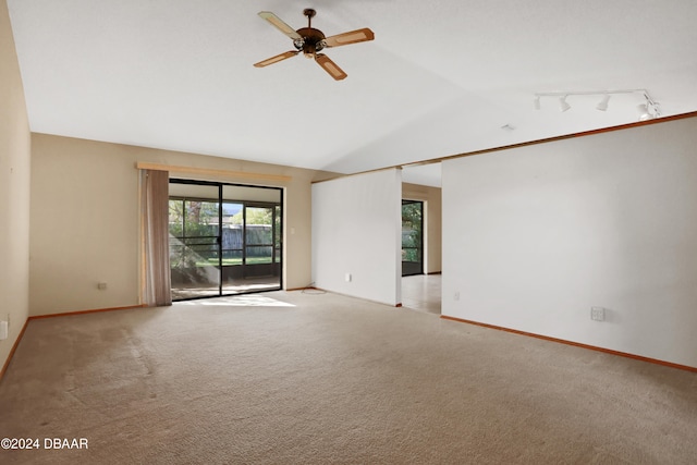 empty room featuring track lighting, vaulted ceiling, ceiling fan, and carpet floors