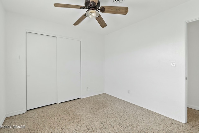 unfurnished bedroom with ceiling fan and a closet