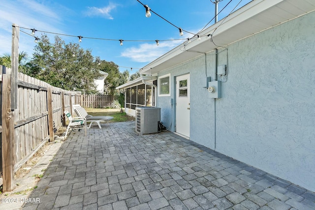 view of patio / terrace featuring central AC unit and a sunroom