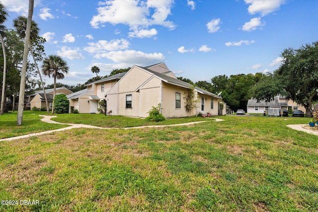 view of side of home with a lawn and a lanai