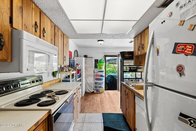 kitchen with white appliances and light hardwood / wood-style flooring