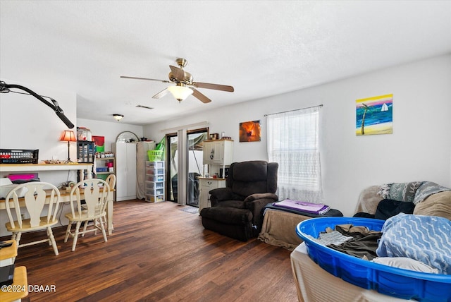 living room with dark wood-type flooring and ceiling fan