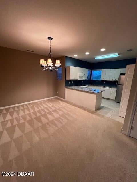 kitchen featuring kitchen peninsula, white appliances, decorative light fixtures, white cabinets, and a chandelier