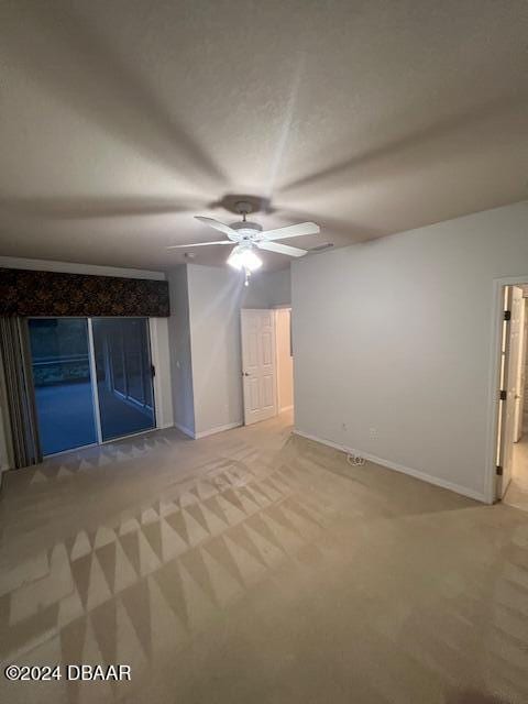 carpeted spare room featuring ceiling fan