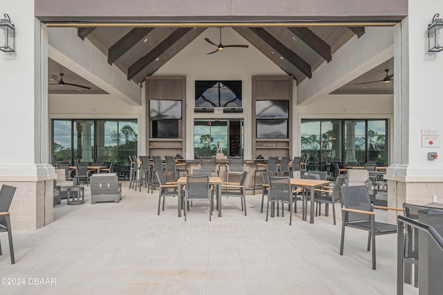 dining space with beamed ceiling, ornate columns, and plenty of natural light