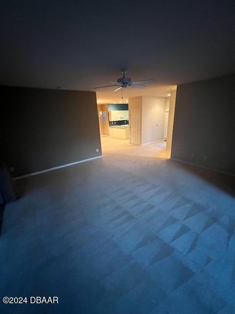 unfurnished living room with carpet flooring and ceiling fan