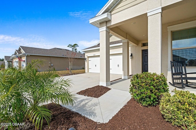 entrance to property with concrete driveway and stucco siding