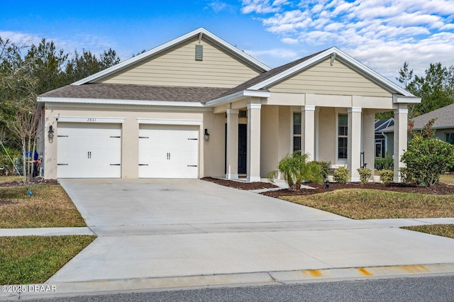 view of front of property featuring a garage, driveway, a shingled roof, and stucco siding