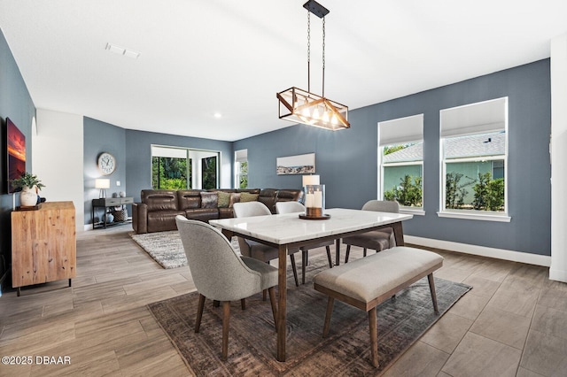 dining room featuring light wood-style floors, visible vents, and baseboards