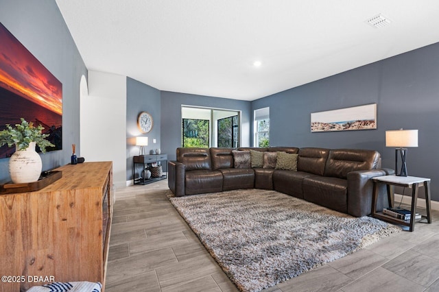 living area with wood finish floors, visible vents, and baseboards