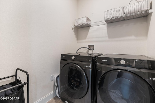 laundry area featuring laundry area, baseboards, wood finished floors, and washing machine and clothes dryer