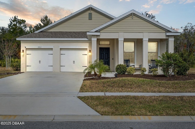 view of front of home with stucco siding, covered porch, roof with shingles, concrete driveway, and a garage