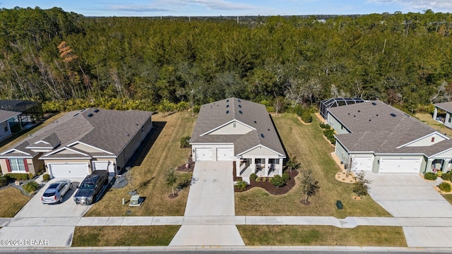 drone / aerial view featuring a residential view and a view of trees