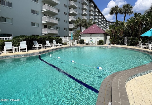 pool with a patio and fence