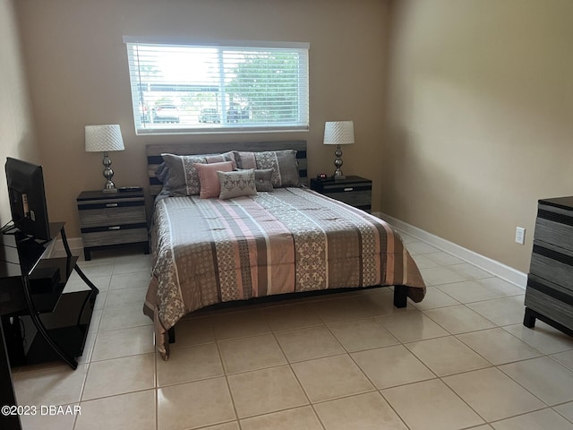 bedroom featuring light tile patterned floors and baseboards