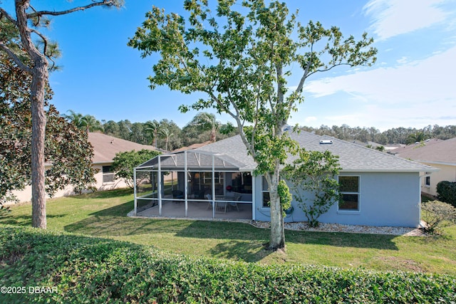 back of property featuring glass enclosure and a lawn