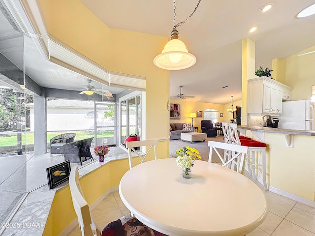 dining area featuring ceiling fan, sink, and light tile patterned floors