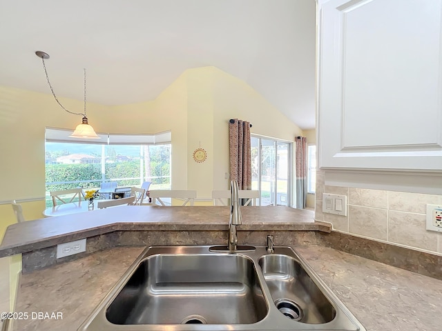 kitchen with white cabinets, a wealth of natural light, sink, and hanging light fixtures