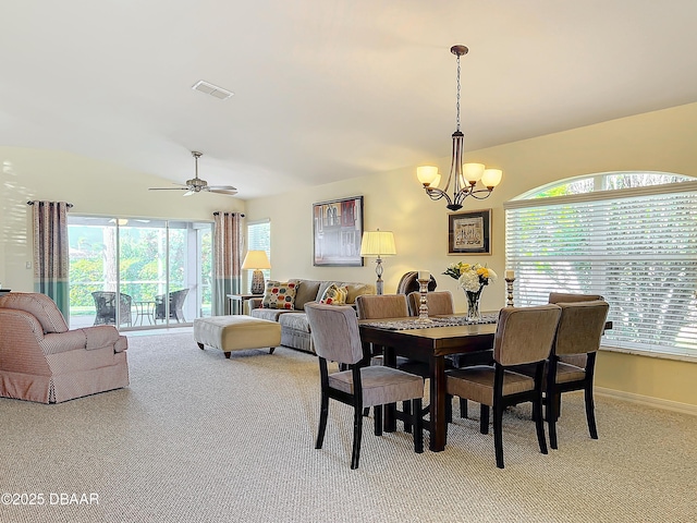 carpeted dining area with ceiling fan with notable chandelier