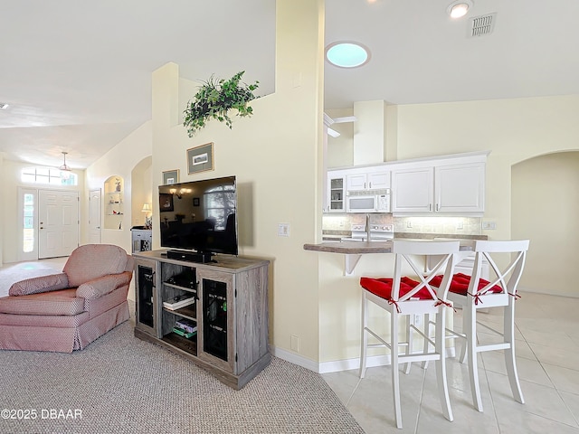 tiled living room featuring vaulted ceiling