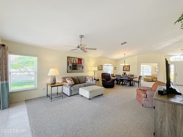 living room with ceiling fan with notable chandelier, light carpet, and vaulted ceiling