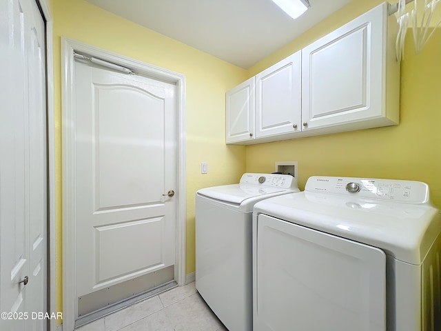 laundry area featuring cabinets, light tile patterned floors, and washing machine and dryer