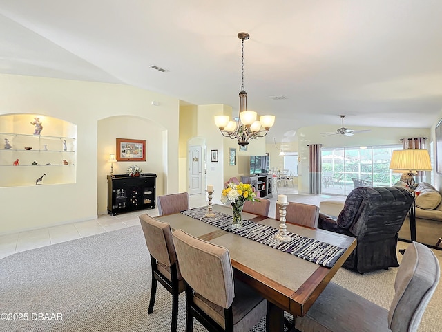 tiled dining room with ceiling fan with notable chandelier