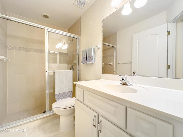 bathroom with tile patterned flooring, vanity, toilet, and a shower with shower door